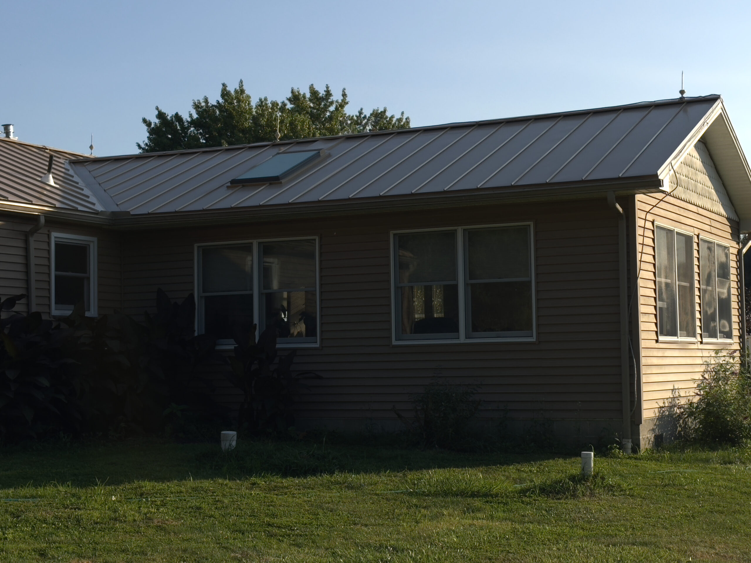 Beige home with silver standing seam metal roof