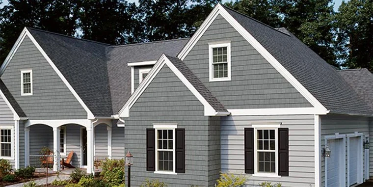 Gray house exterior with black shutters and shingle roof