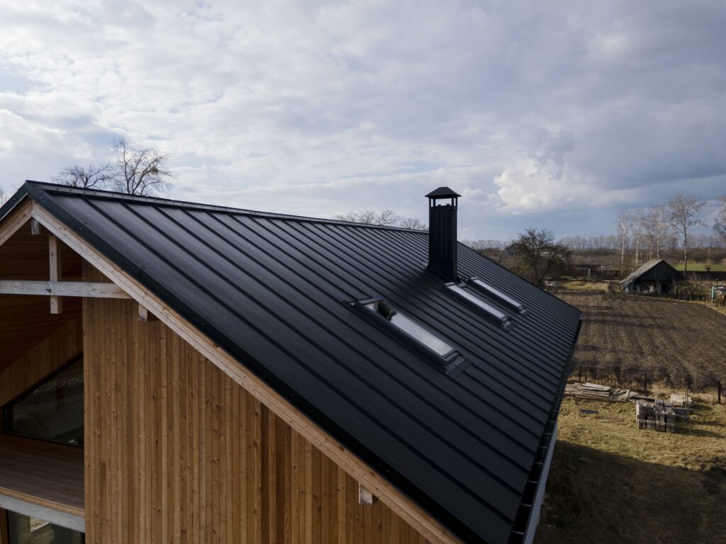 Aerial view of a black metal roof with a chimney.