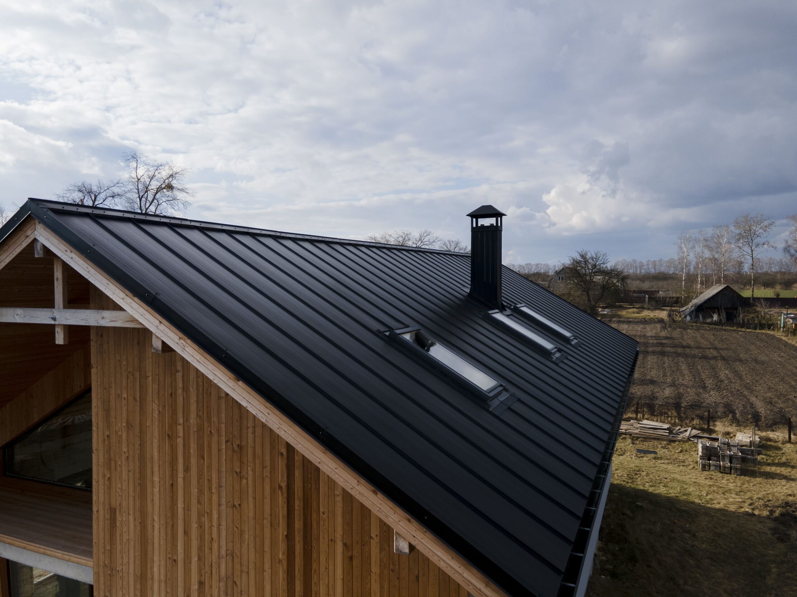 Aerial view of a black metal roof with a chimney.