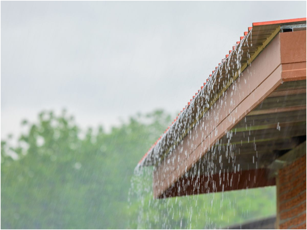 Rainwater flowing off metal roof without gutters installed
