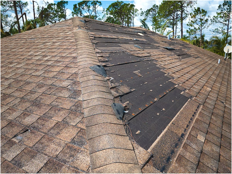 Roof with missing shingles and visible storm damage