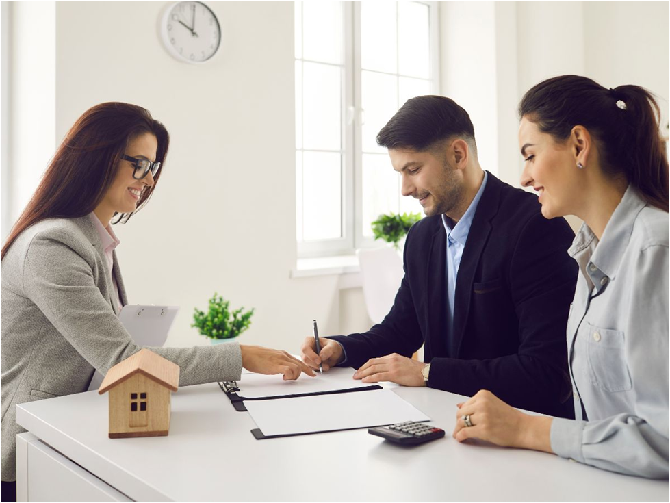 Couple signing contract with real estate agent