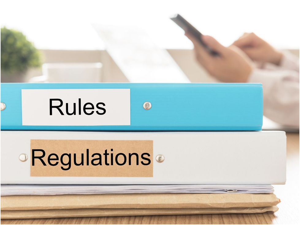 Binders labeled rules and regulations on desk