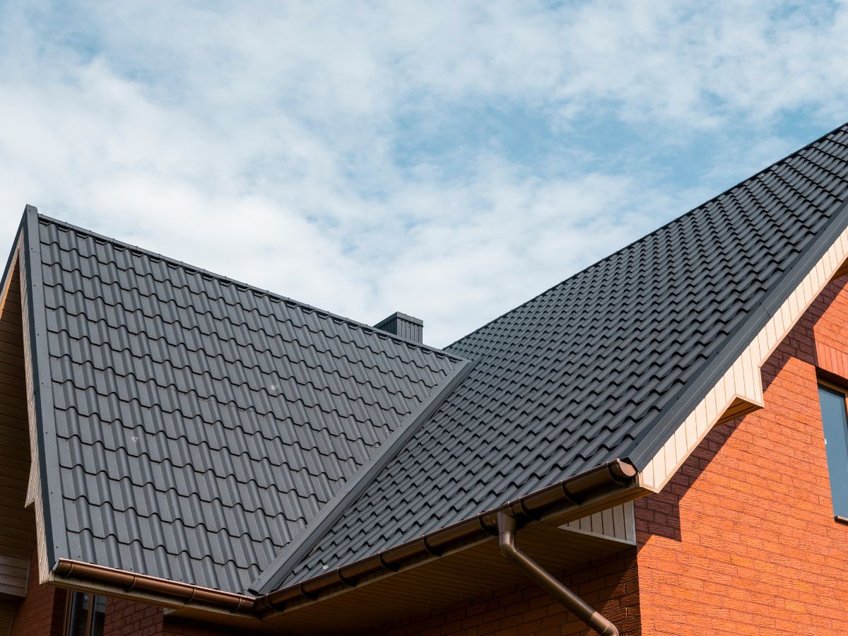 Dark gray metal roof on modern brick house exterior